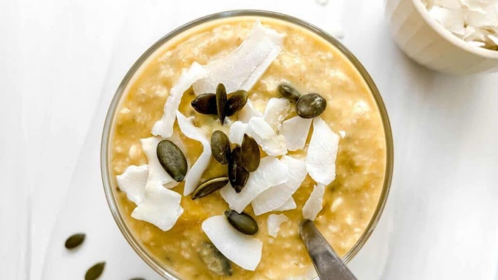 Mango Coconut Overnight Oats in a jar with a spoon. 