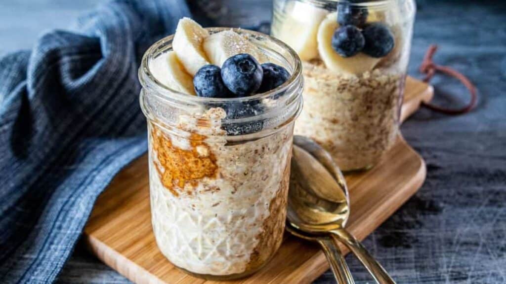 Peanut butter overnight oats with blueberries and bananas on a blue background. 