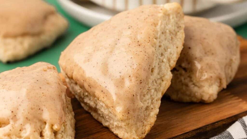 Vanilla Bean Scones in a row on a wooden board on a table.