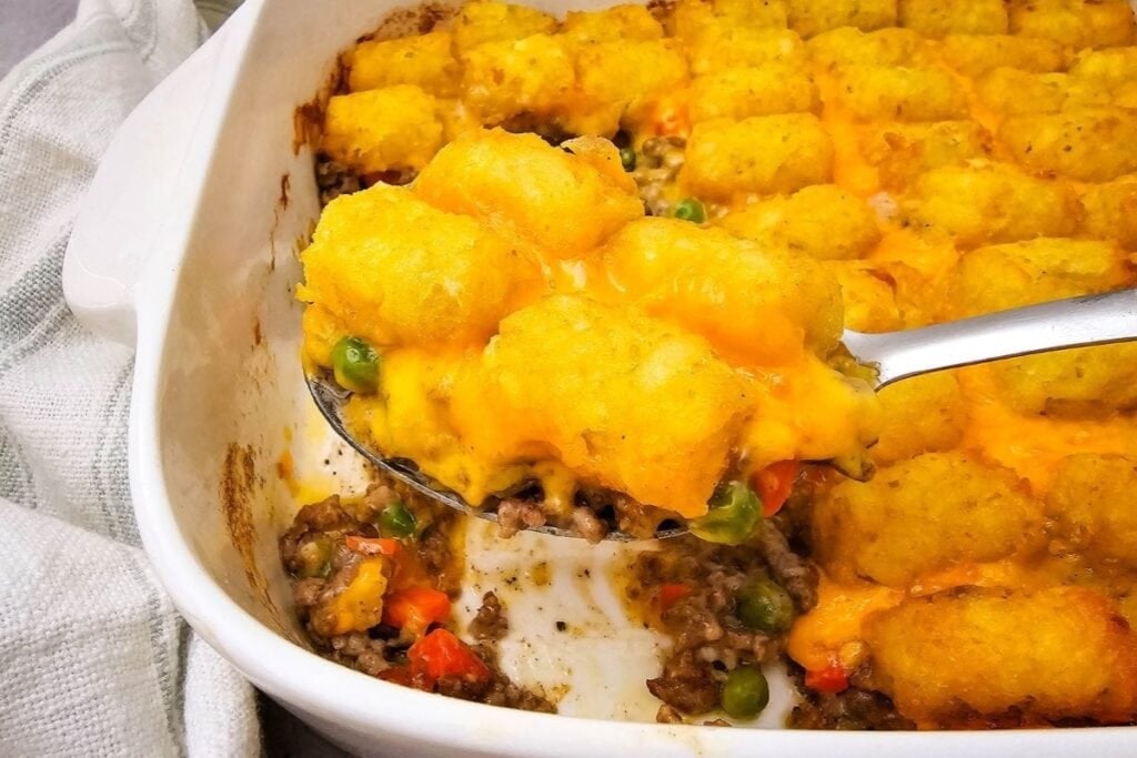Tater tot casserole with ground beef in a baking dish.