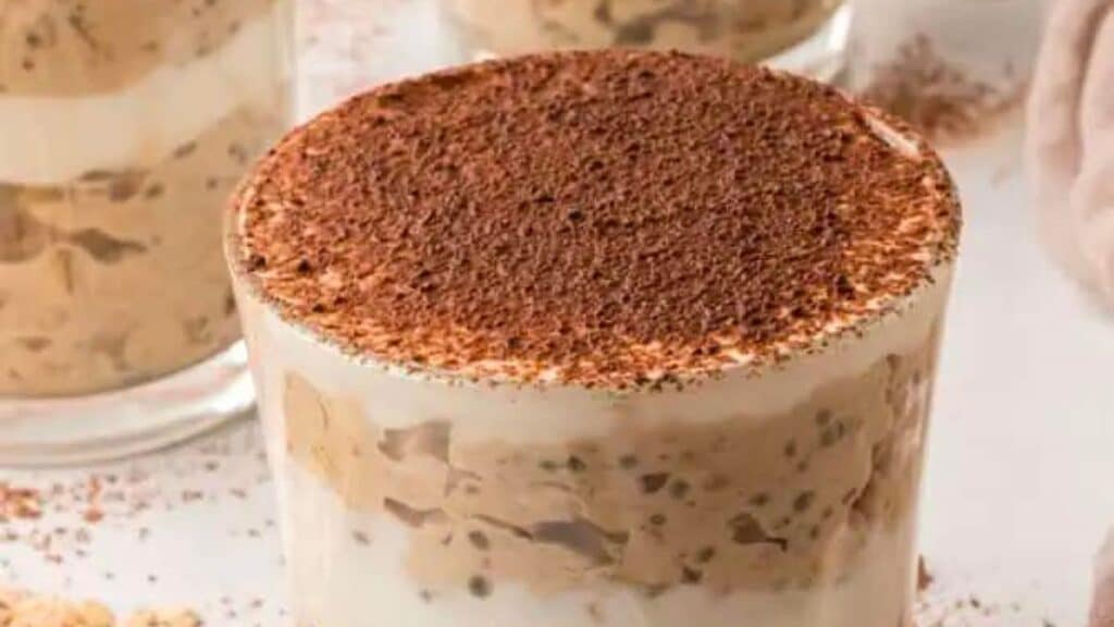 tiramisu overnight oats in a jar on a white background.