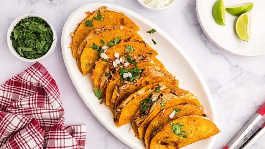Chicken birria tacos on a white plate.