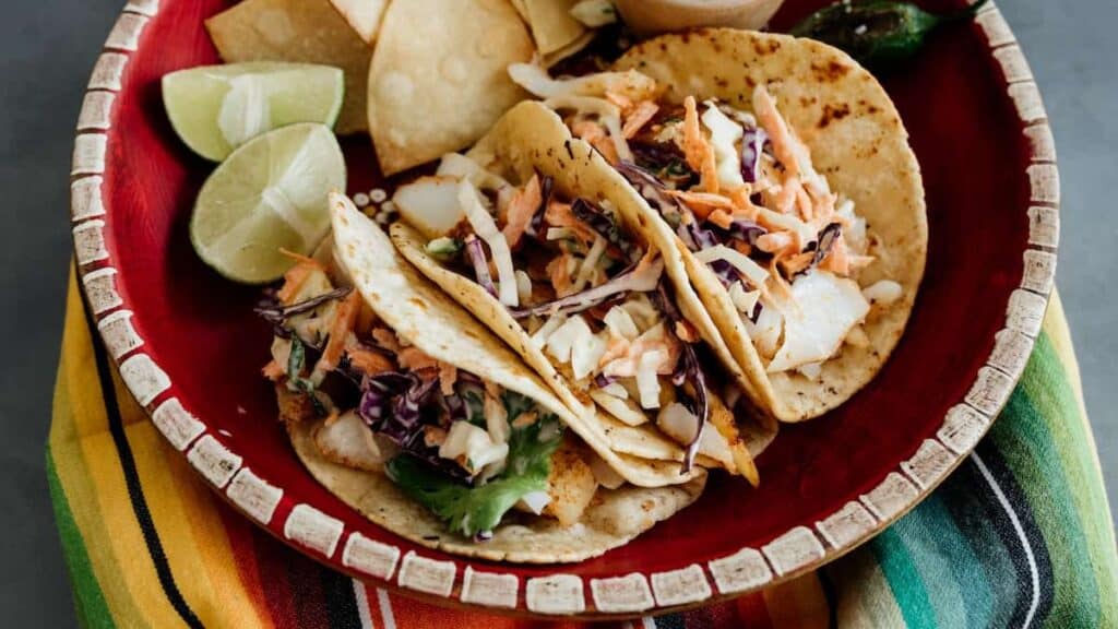 Fish tacos on a red plate.
