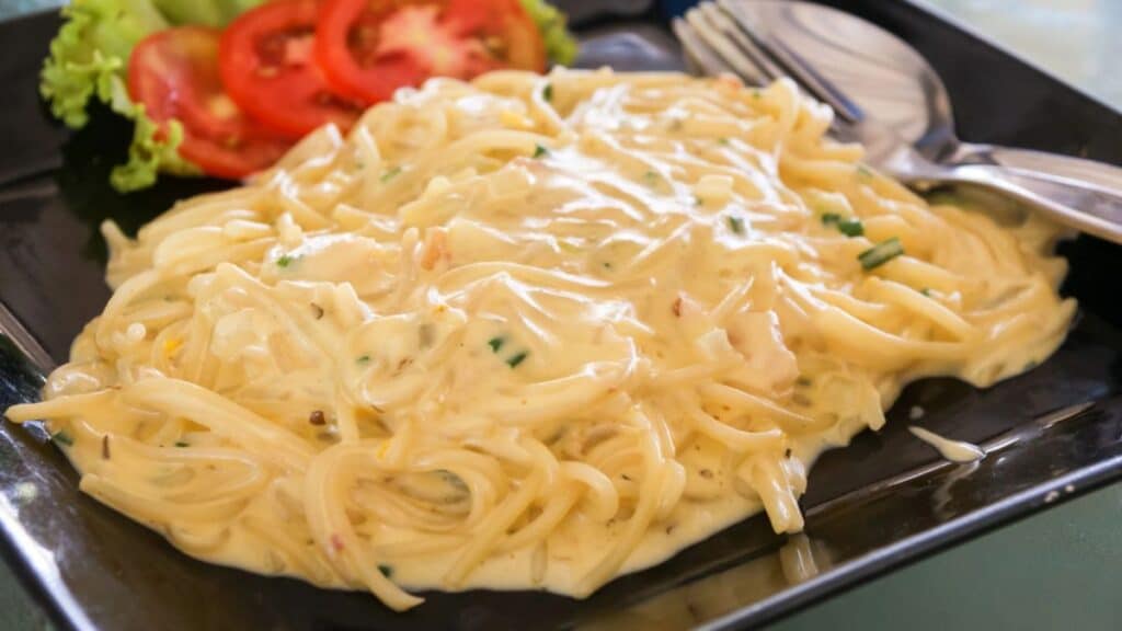 Cheesy spaghetti on a black plate