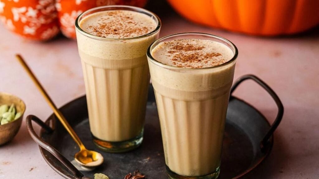 Iced Pumpkin Cream Chai on a black tray with spoon.