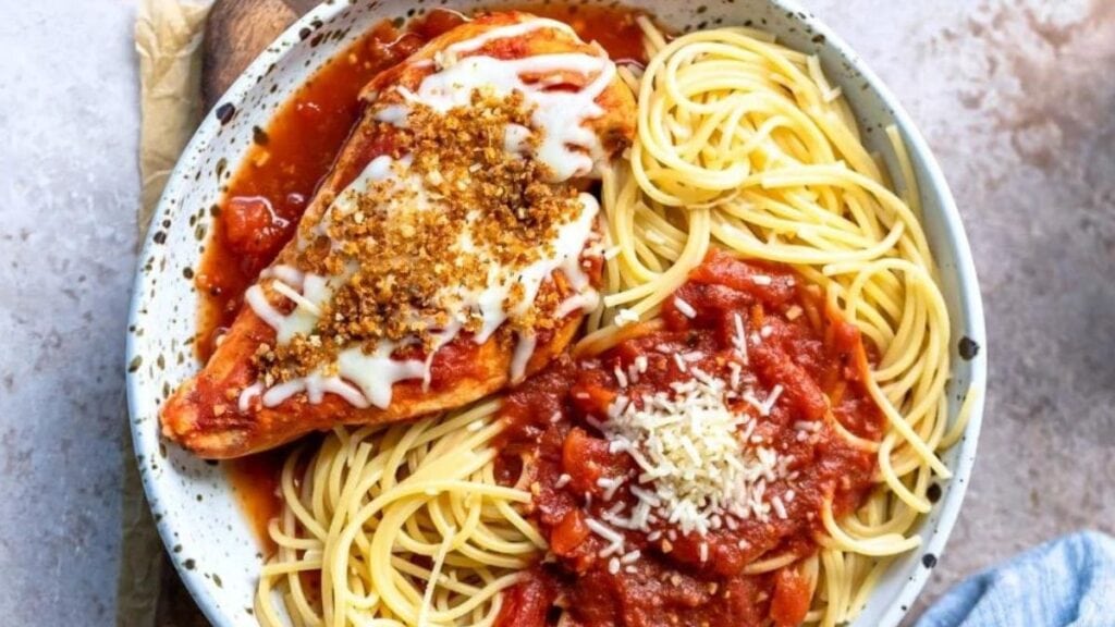 A plate of slow cooker chicken parmesan on a counter.