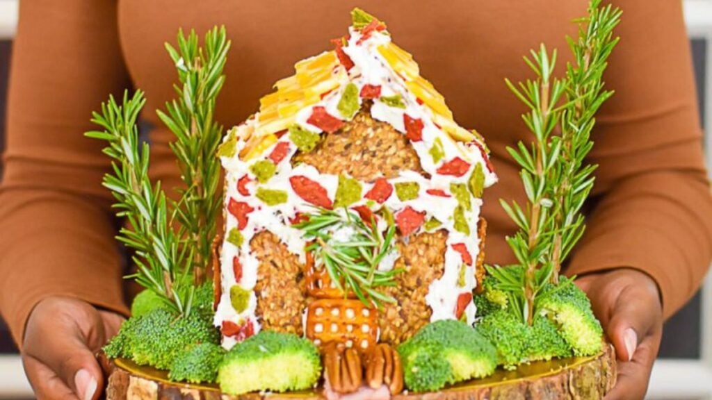 Charcuterie house with green herbs in front.