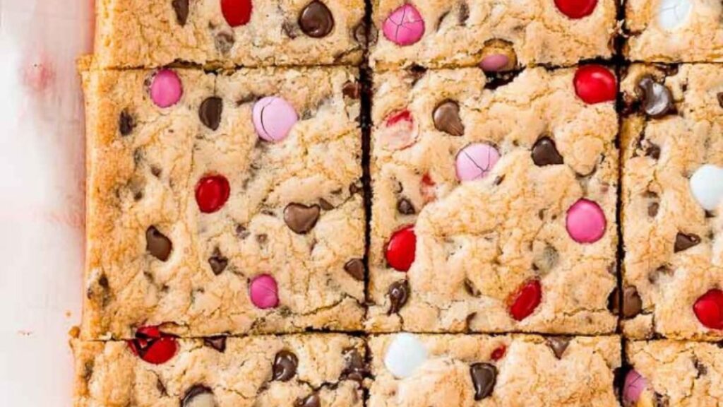 Chocolate chip cookie bars cut into squares with M&M candies.