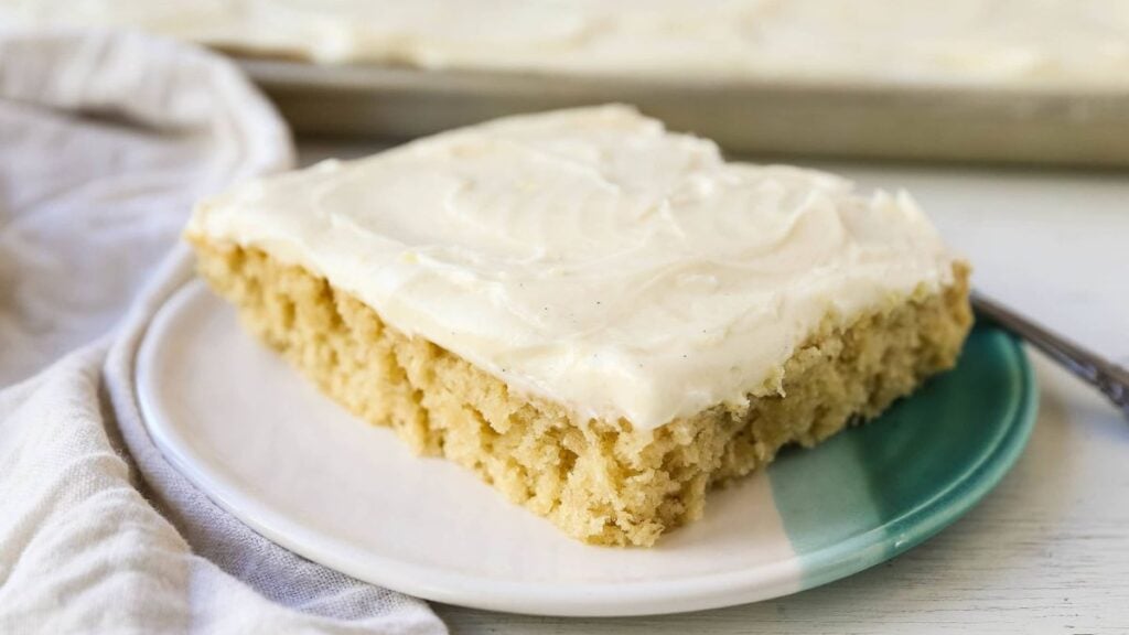 A piece of banana sheet cake on a plate.