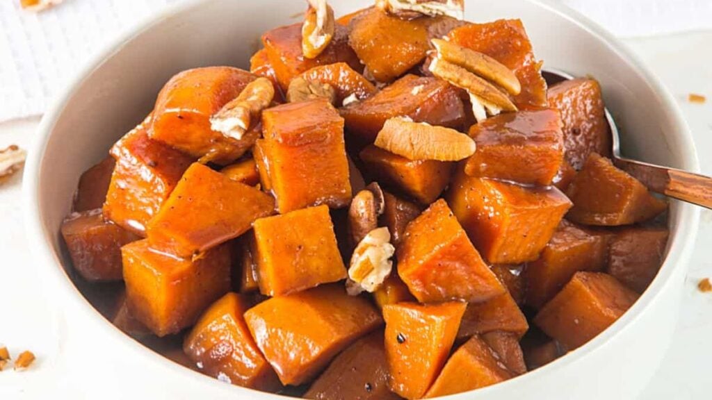 Candied sweet potatoes in a white bowl.