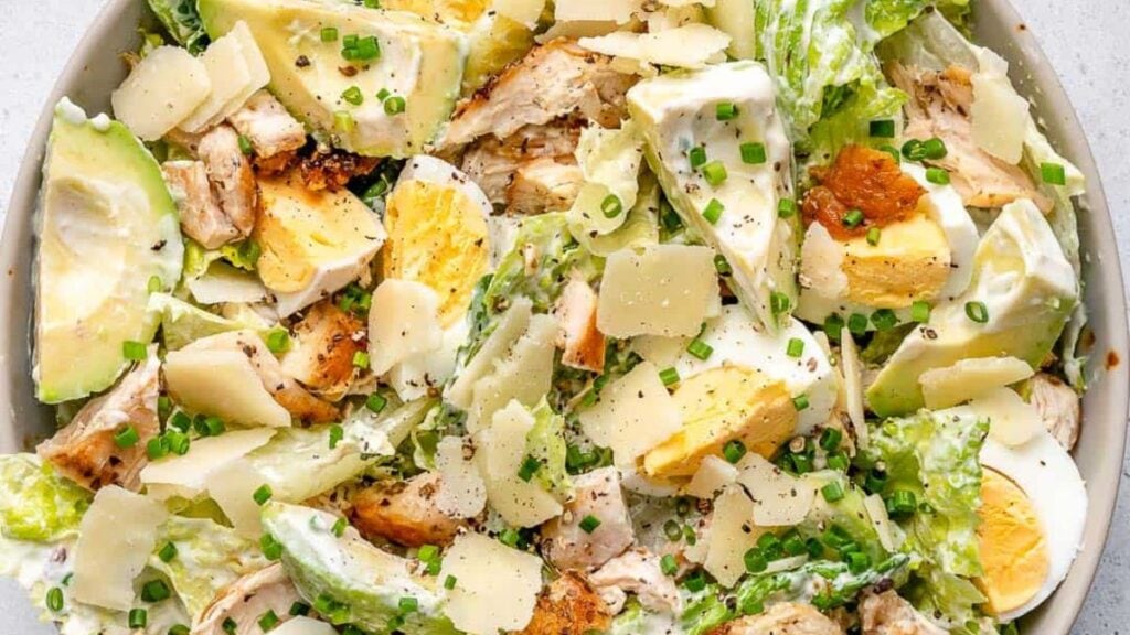 A close up of chicken caesar salad on a plate.