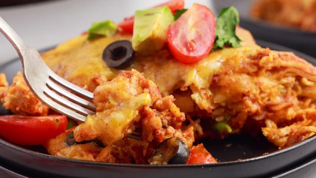 A piece of chicken enchilada casserole on a plate.