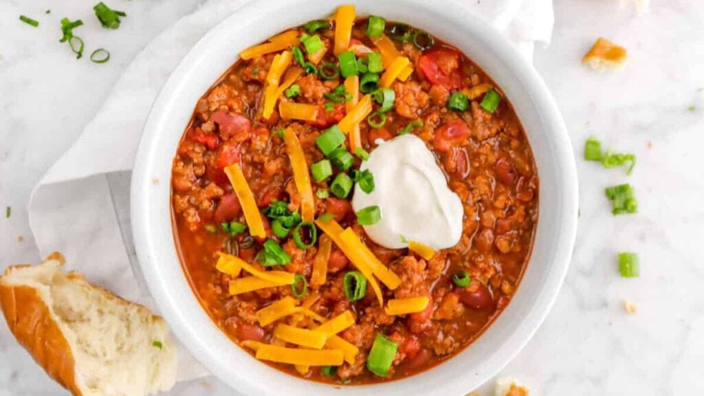 A hearty bowl of chili in a white bowl. 