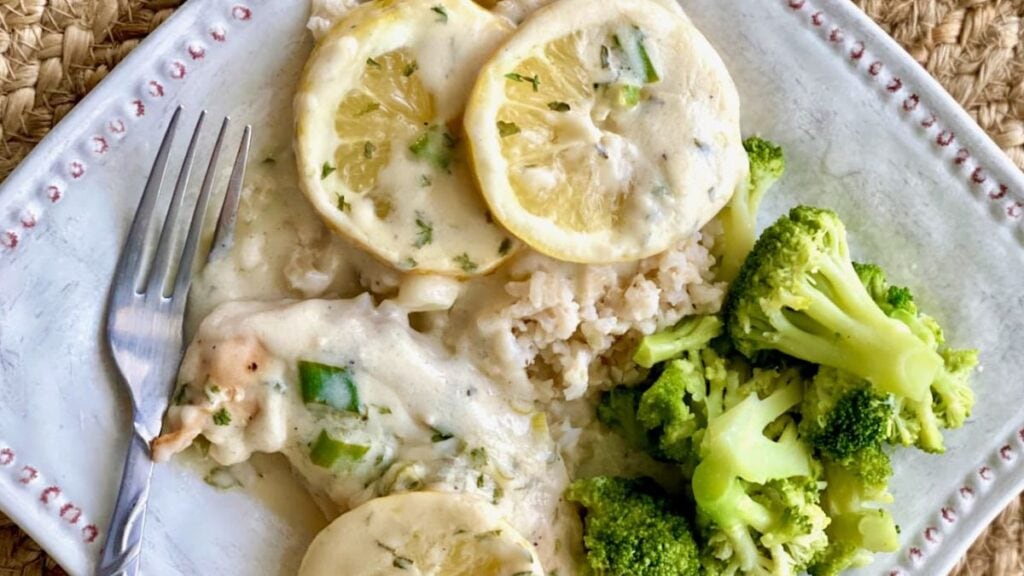 Creamy chicken with sliced lemons and broccoli.