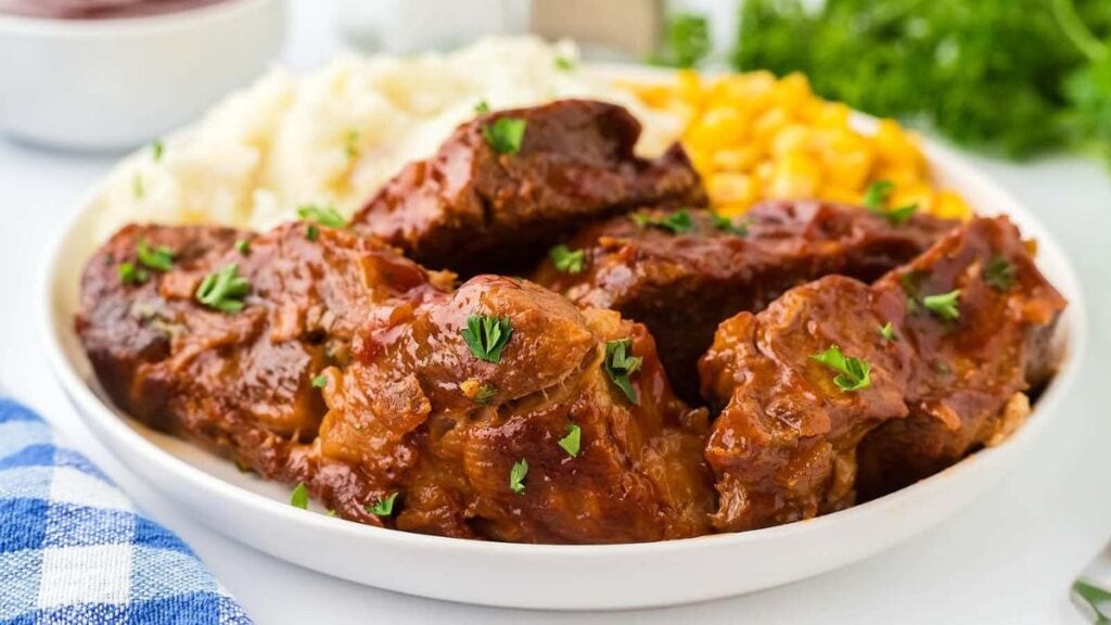 Close up shot of pork ribs on a white plate.