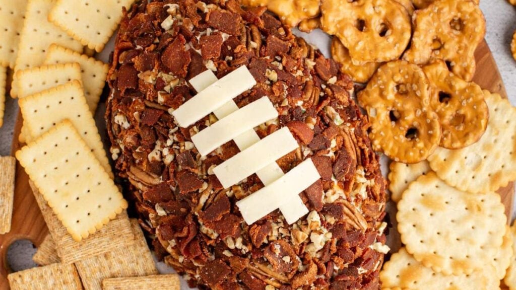 A soft cheeseball shaped like a football that's covered with crispy bacon and chopped nuts.