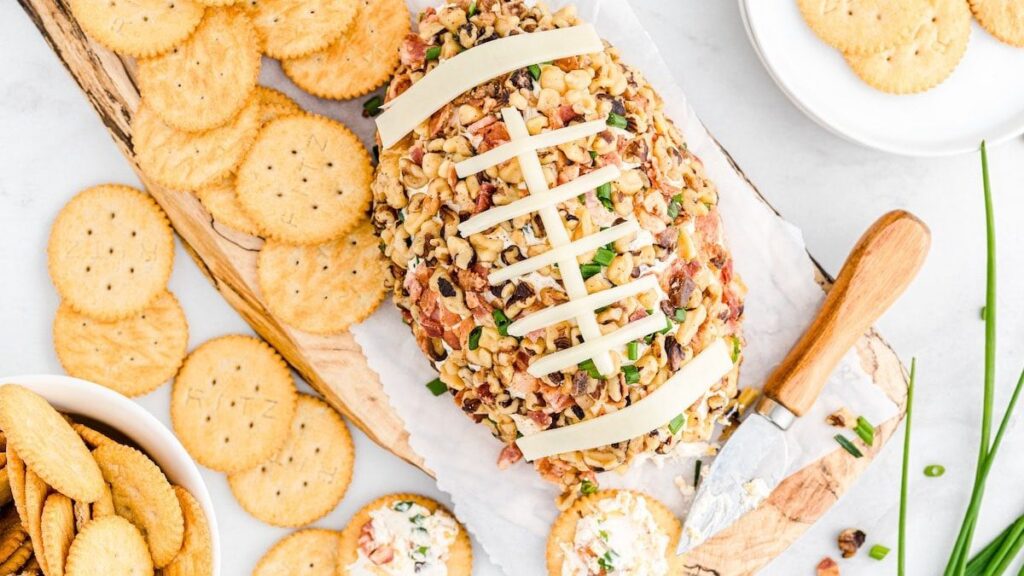 Cheeseball shaped like a football covered in nuts. 