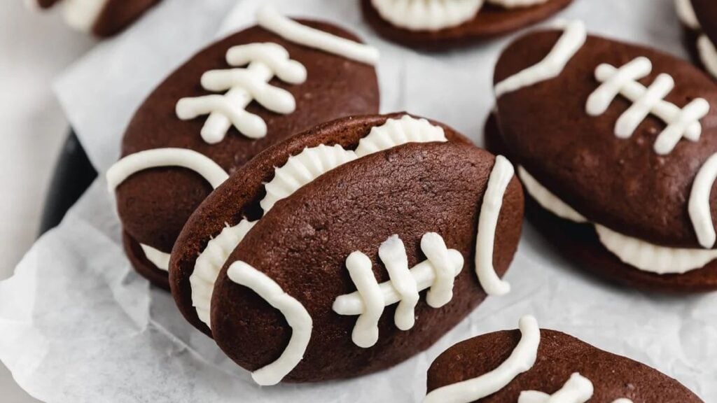Chocolate whoopie pies shaped like footballs.