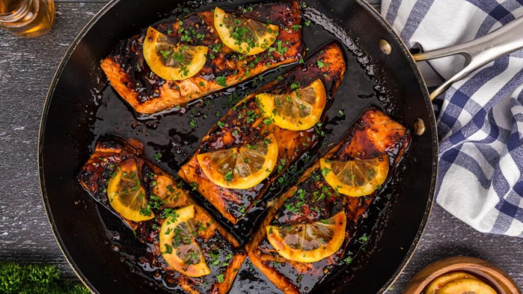 Honey salmon with sliced lemons on top.