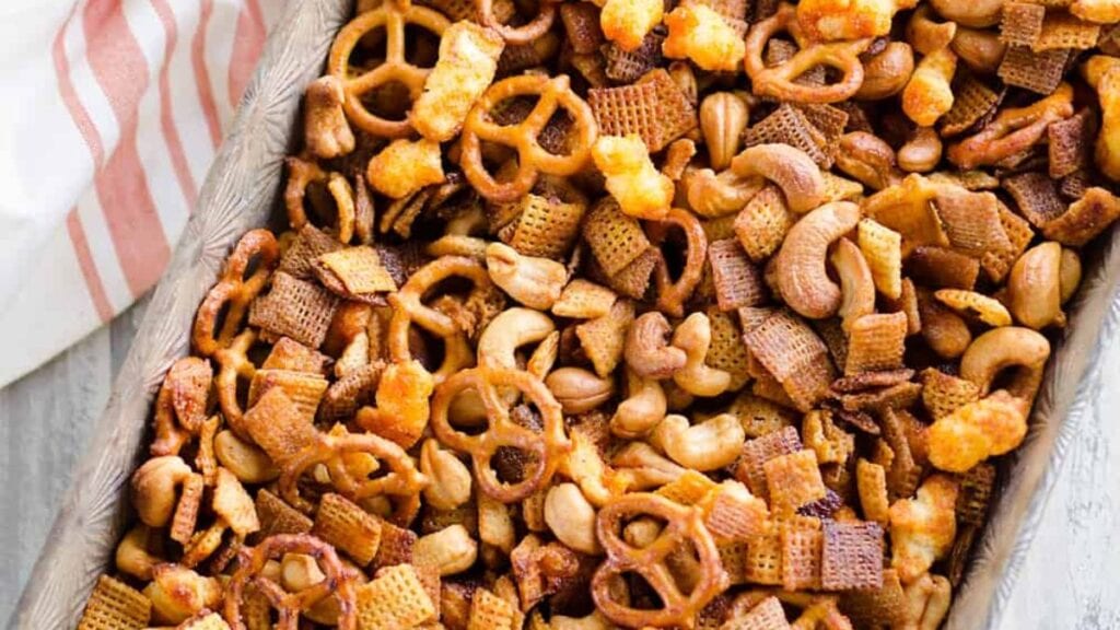 Party snack mix in a baking dish on a table.
