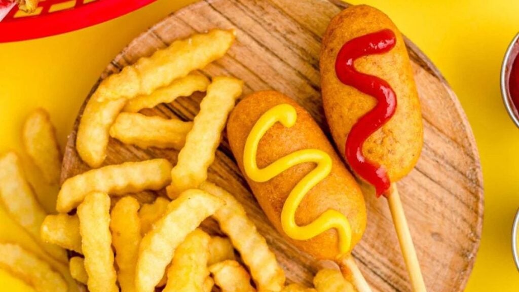 Mini corn dogs with ketchup and mustard.