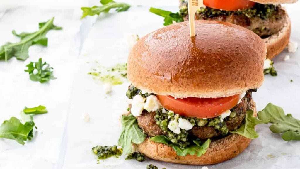 Chicken burger with pesto and tomato.