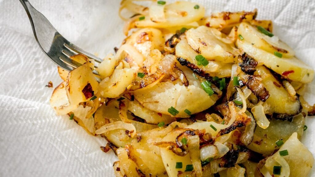 Fried potatoes with onions on a plate.