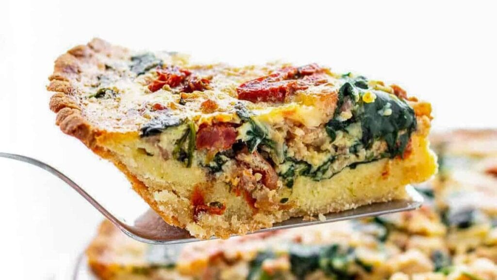 Quiche made with spinach and bacon on a plate.