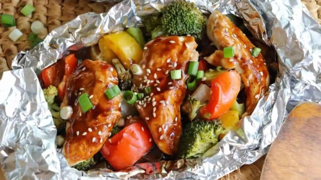Chicken paired with bell peppers and broccoli, all wrapped and cooked in foil.