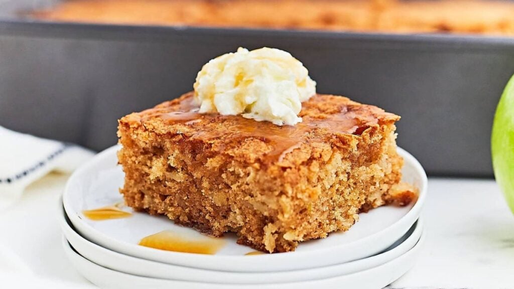 Slice of apple cake on a white serving plate.