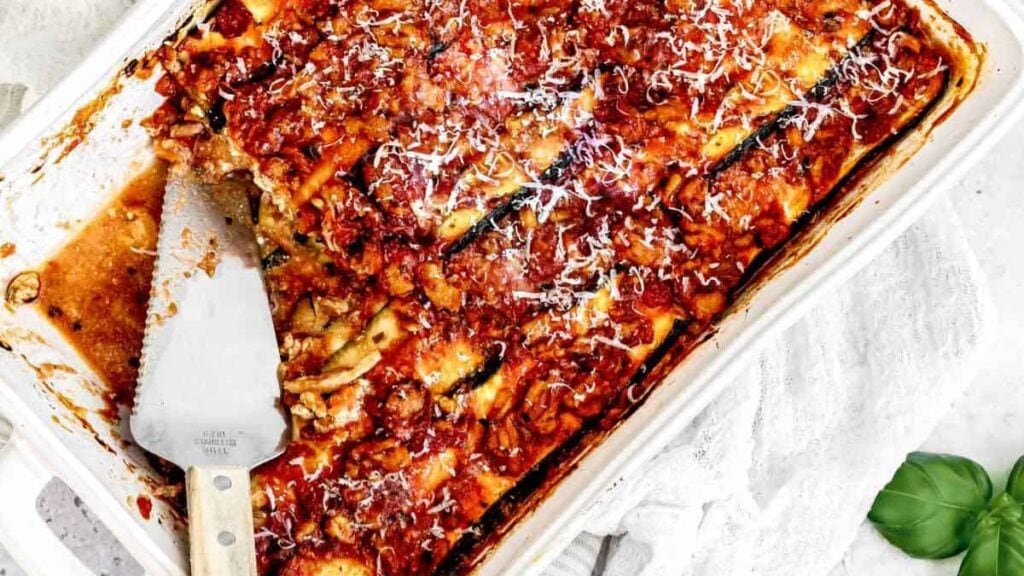 Zucchini lasagna in a white pan on the table.