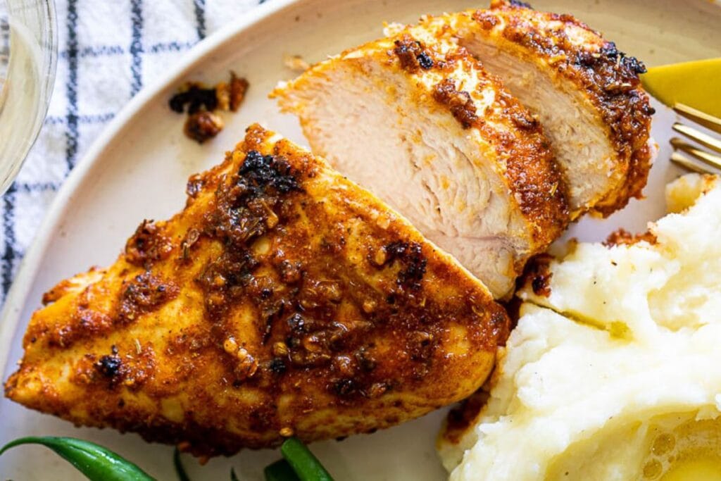 Juicy chicken breast served with a side of mashed potatoes.