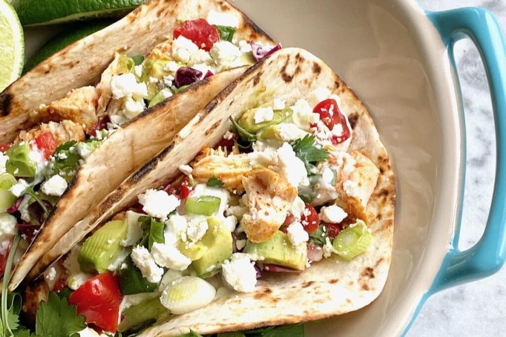 Baja style chicken tacos on a plate.