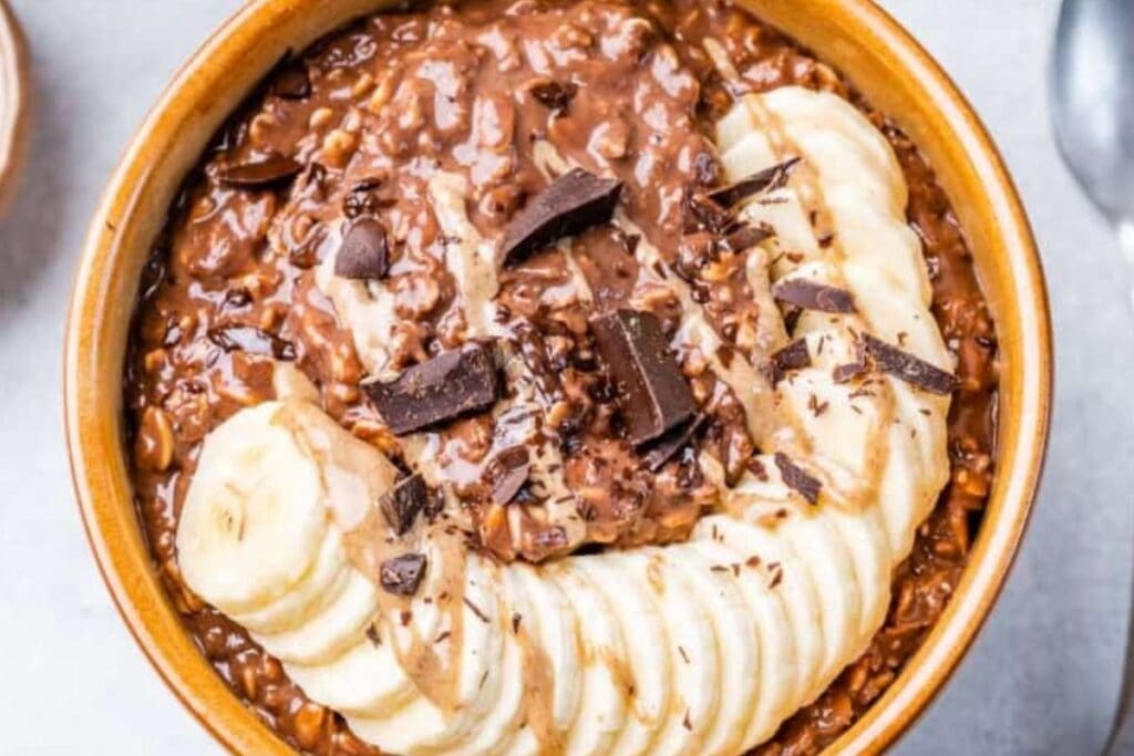 Chocolate and peanut butter smoothie bowl topped with sliced bananas. 