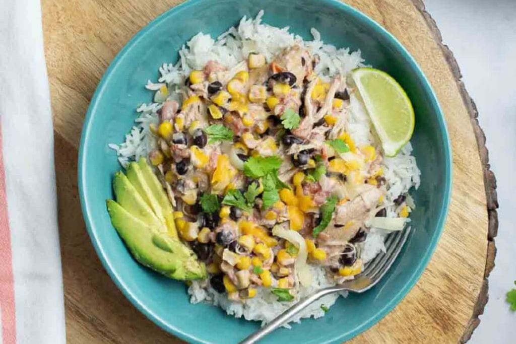 Rice with chicken and sliced lime on a plate.