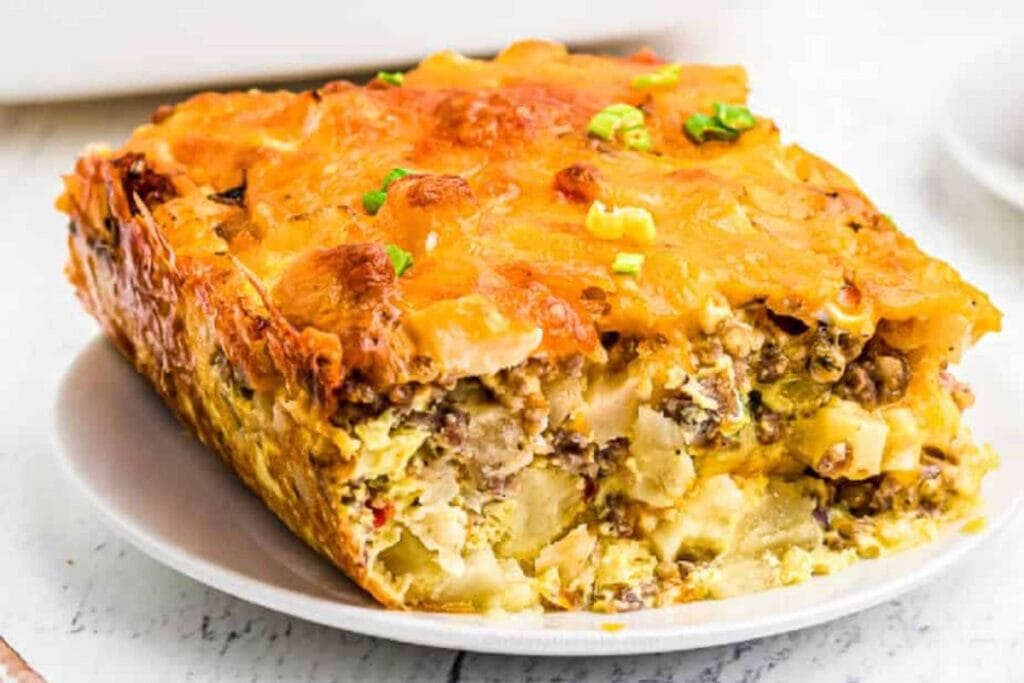 A slice of sausage potato casserole on a plate.