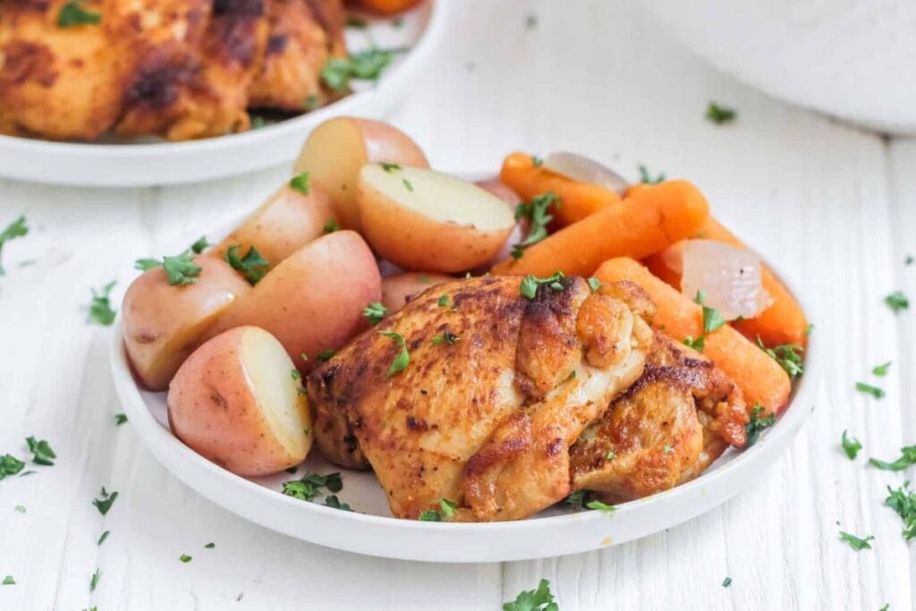 Chicken thighs and potatoes on a plate.