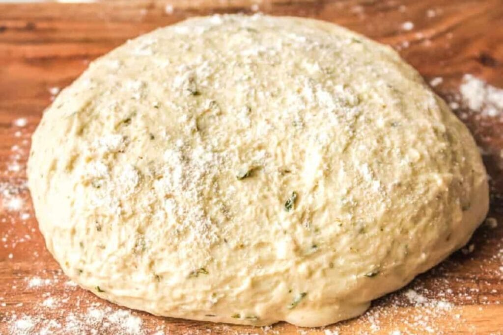 Pizza dough on a wooden board.