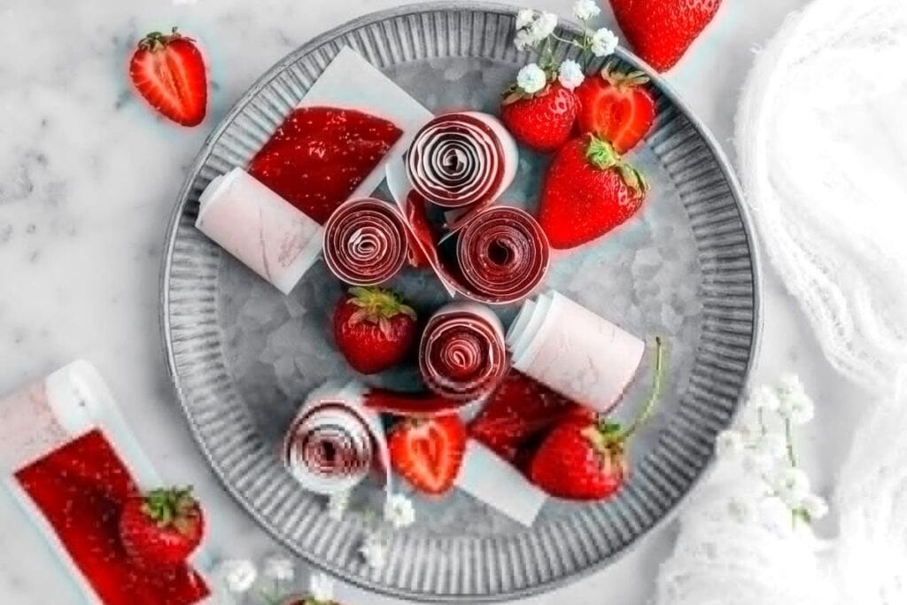 Strawberry fruit roll ups on a plate.