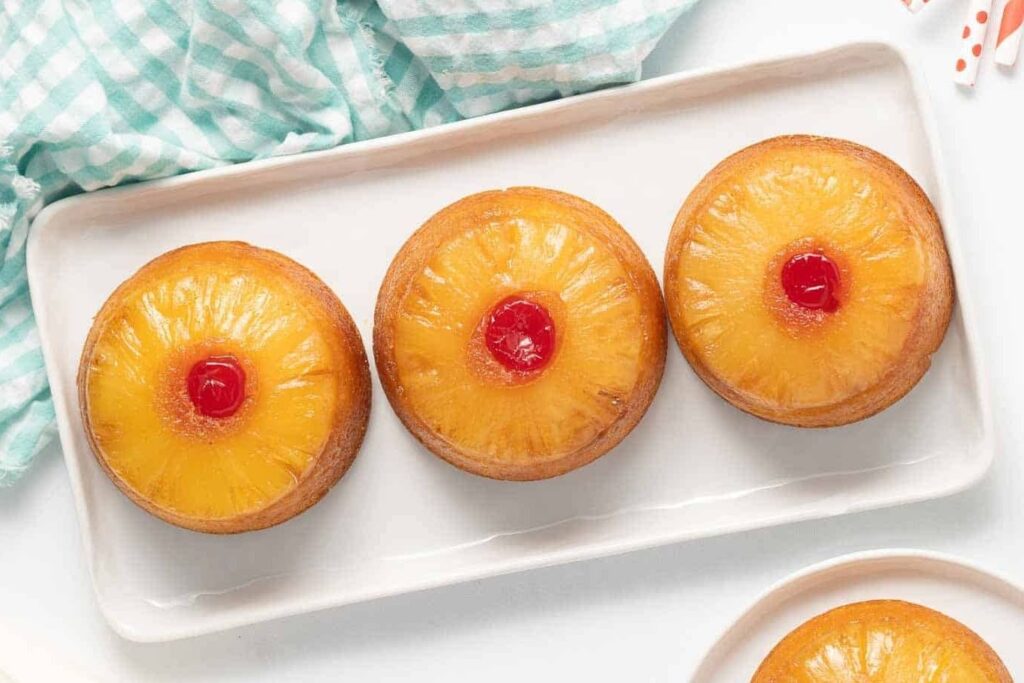 Pineapple upside down cakes on a plate.