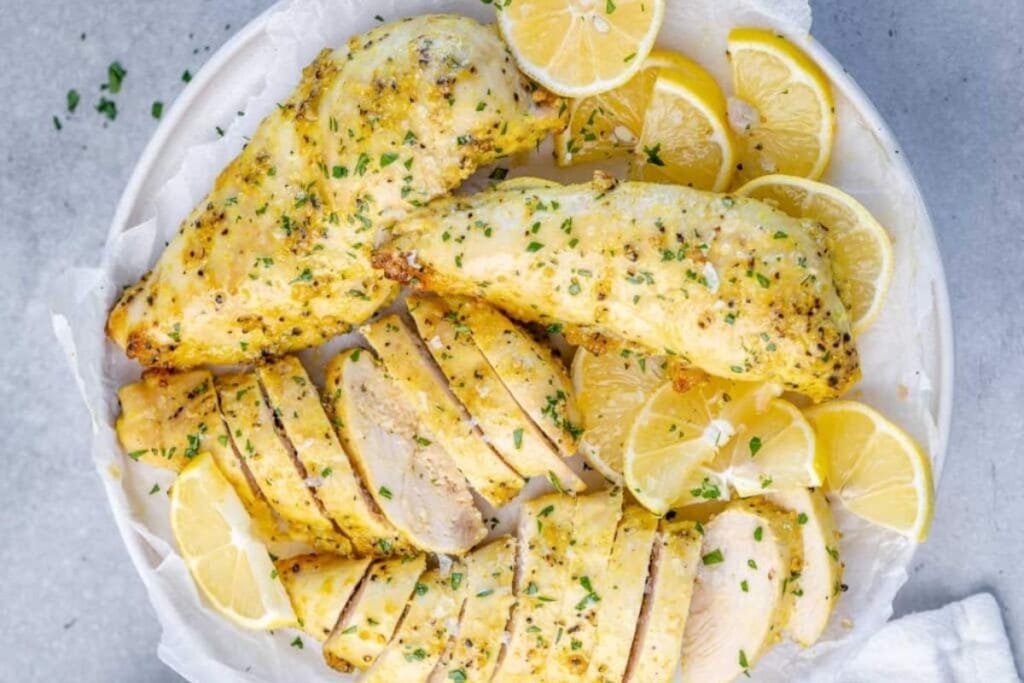 Chicken breast with lemons on a plate.