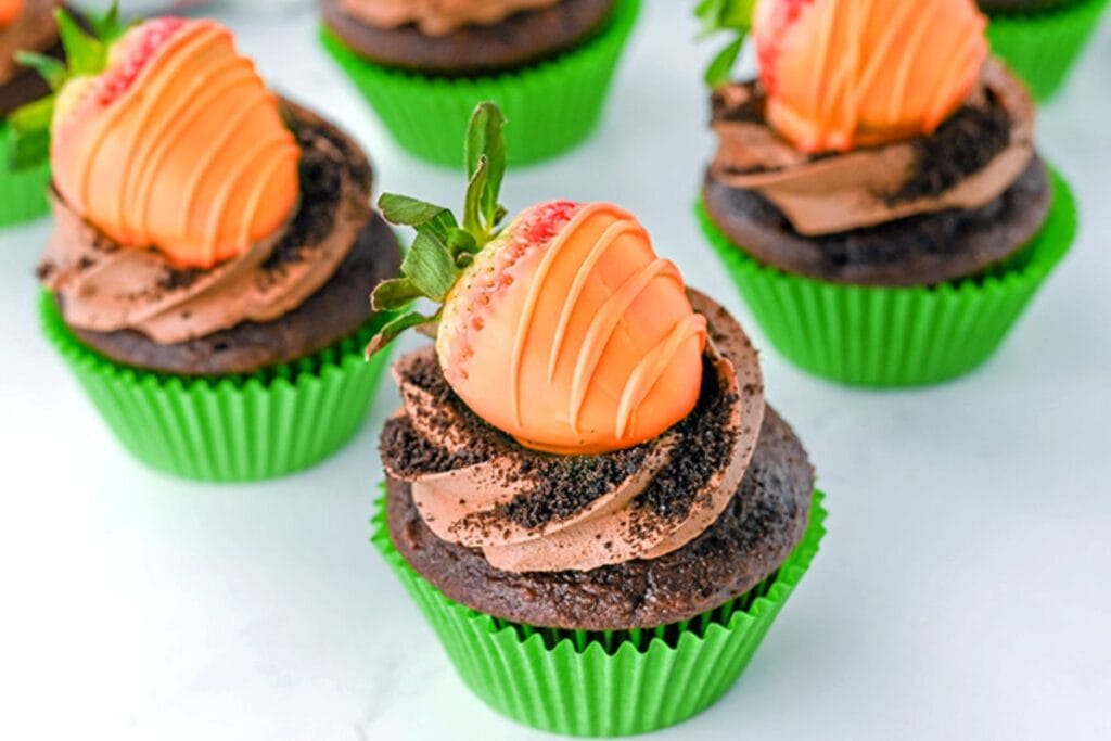 Carrot cupcakes on a white surface.