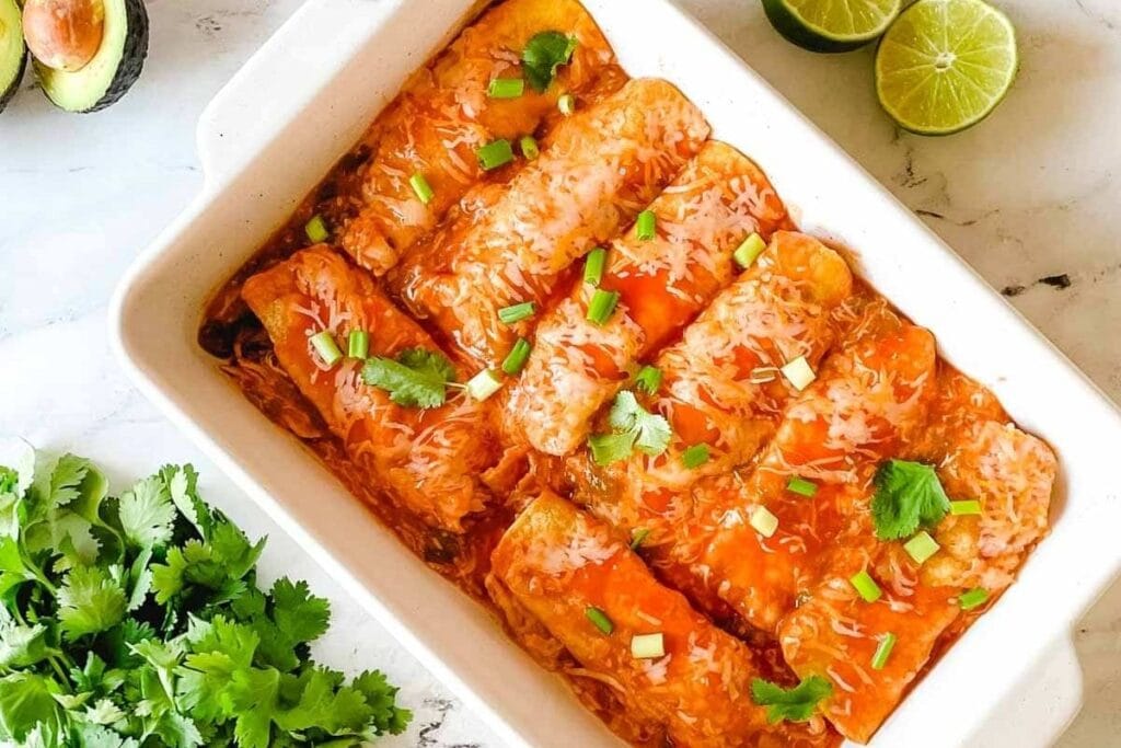Chicken enchiladas in a white dish.