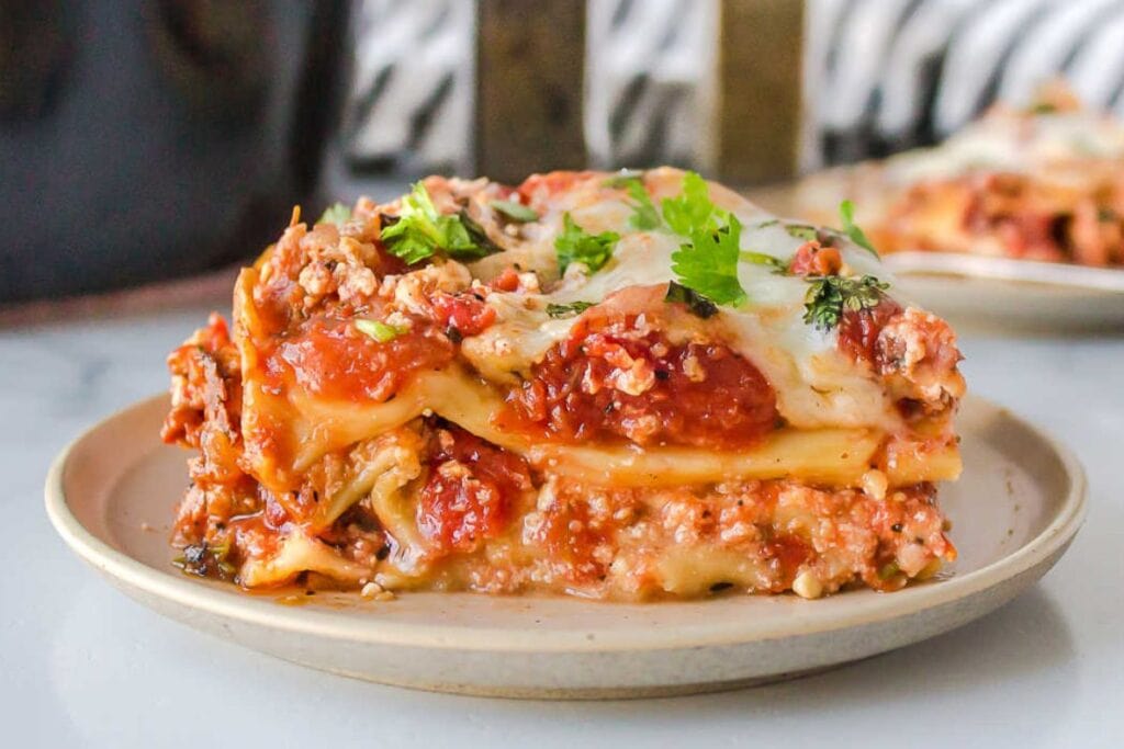 A slice of lasagna on a plate.