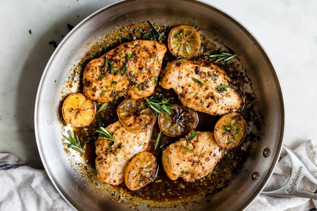 Lemon rosemary chicken in a pan.