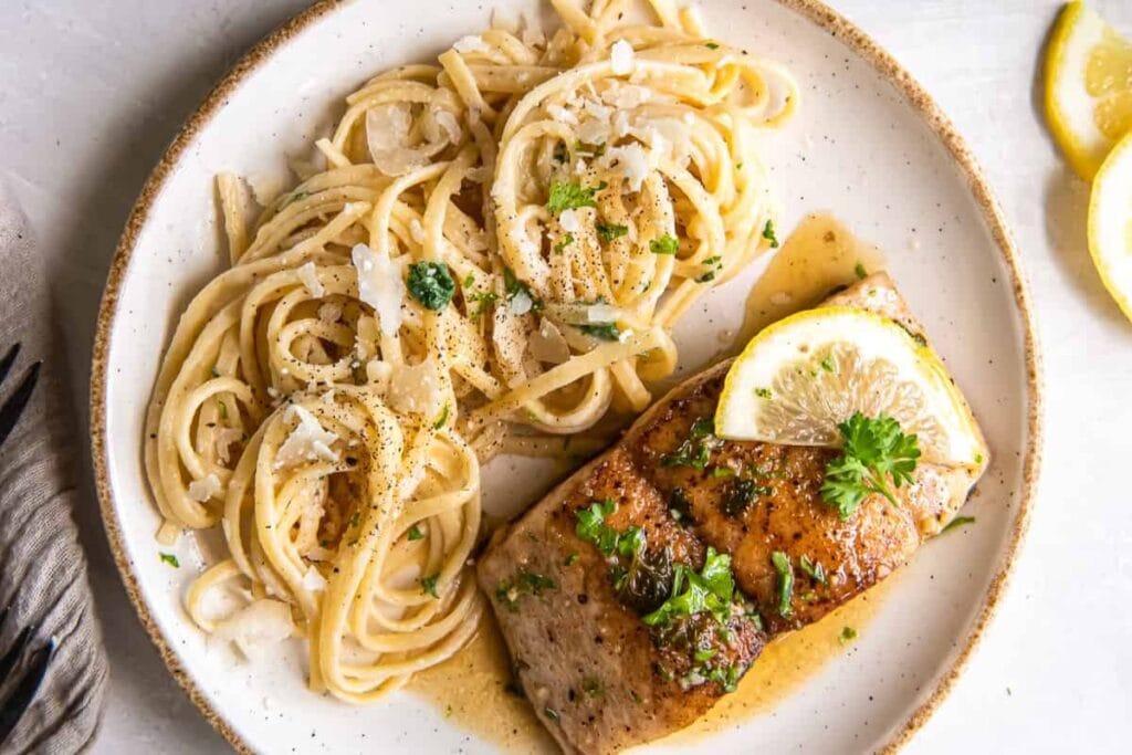 Pasta and mahi mahi on a plate.
