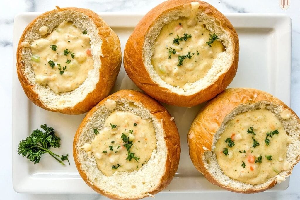 Clam chowder bread bowls on a plate.