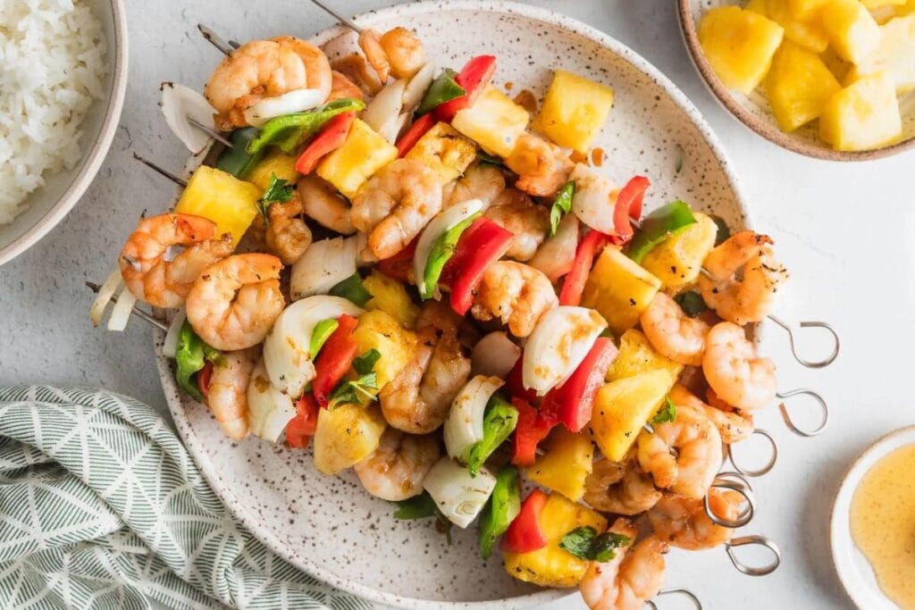 Shrimp pineapple skewers on a plate.