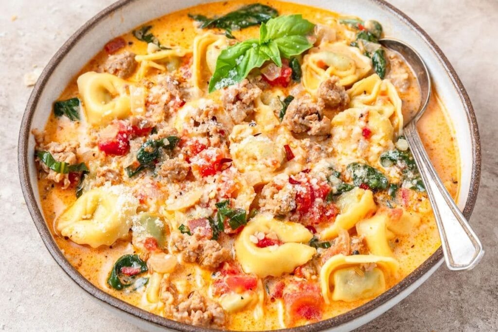 A bowl of spinach tortellini soup.
