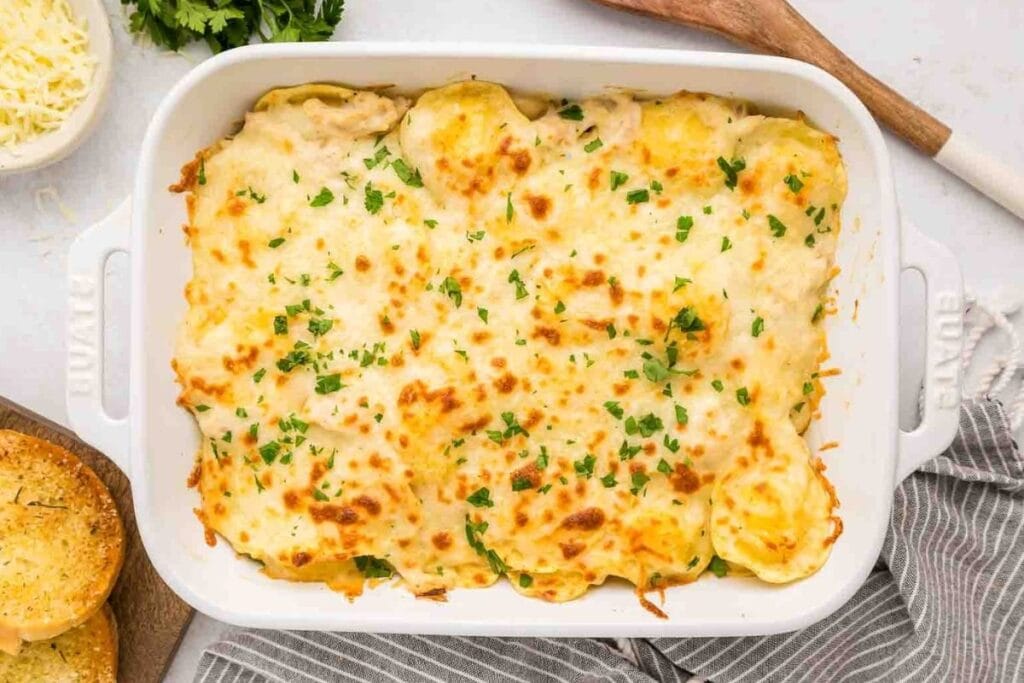 Chicken alfredo baked ravioli in a white dish.